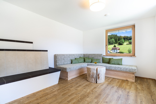 Wohnzimmer mit heizbarer Ofenbank und XXL-Sofa